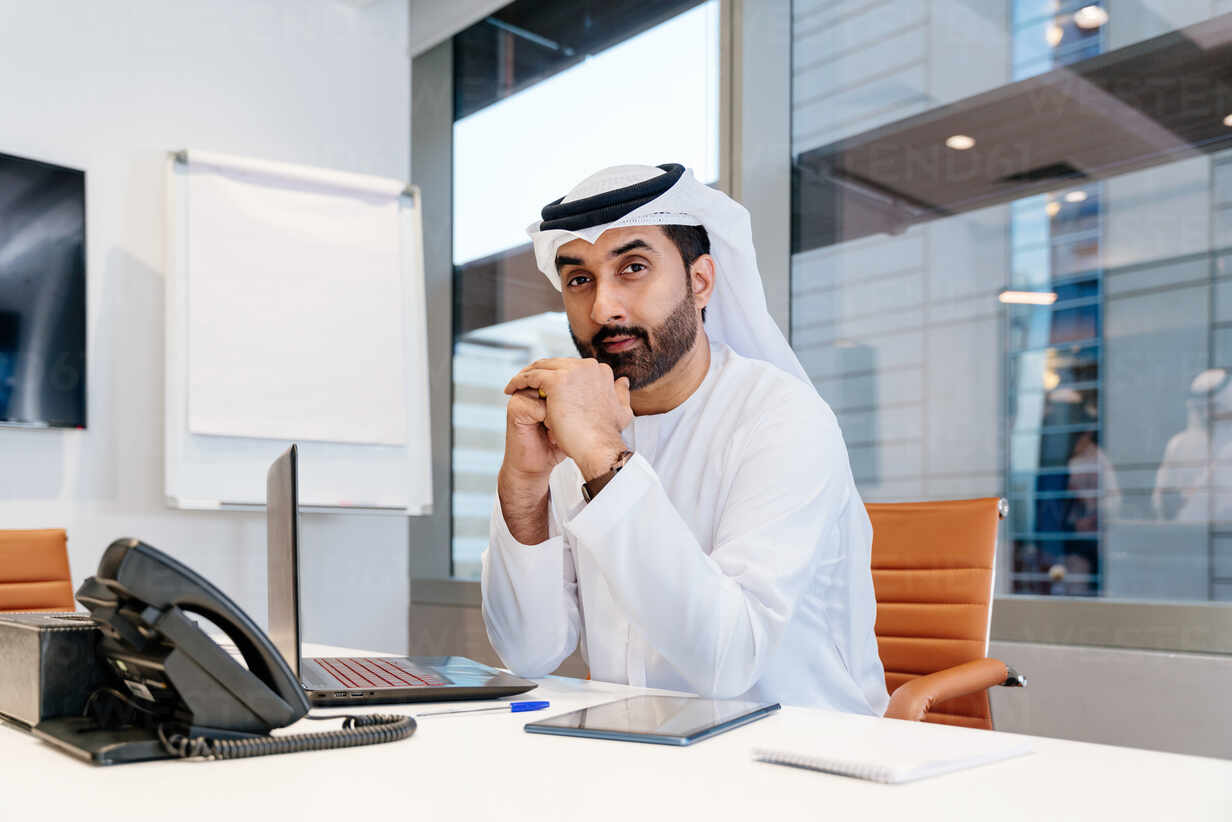 Home 8 middle eastern businessman wearing traditional arab kandura working in the office in dubai adult arabian business man working in the uae DMDF02248